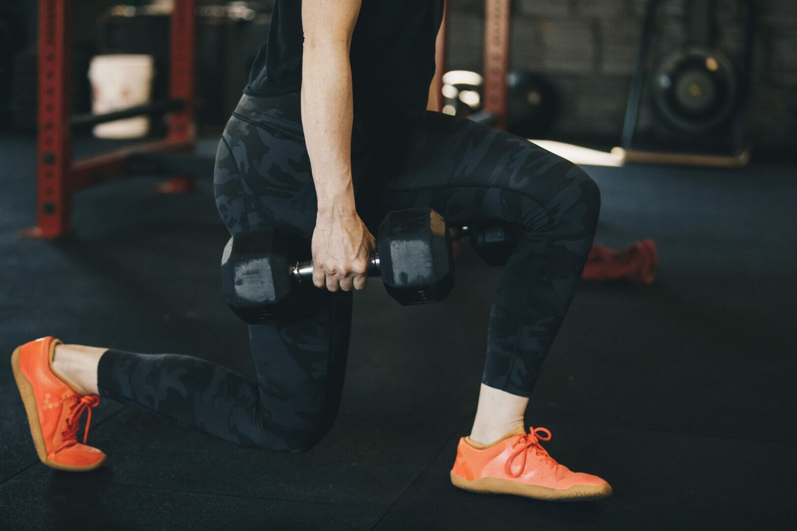 woman doing walking lunges with barbell